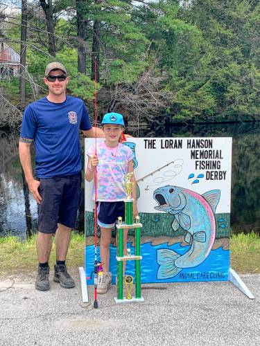 Peterborough Fire Department Lt. Cody Boutwell, left, after the  2022 fishing derby. The trophy is the Don Rodenhiser Trophy, given to the winner every year.
