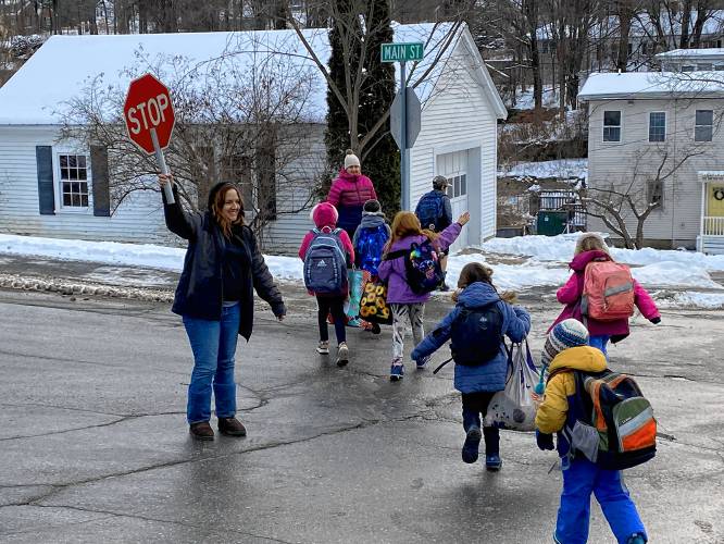 Peterborough Elementary School crossing guard Jessica Hamlin holds up traffic as students cross the street Thursday.