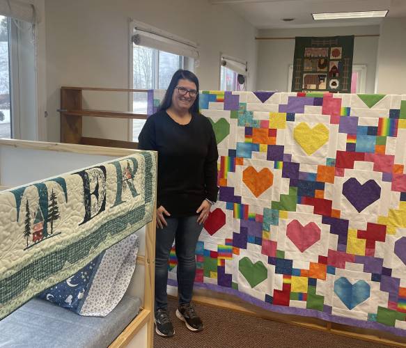Nichole Schneider, owner of Leila’s Stitch Haven in Lyndeborough, shows  two of her quilts. 