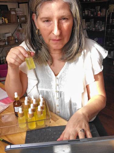 Nanette Perrotte of Lux Lifestyle prepares a shipment of Lux Face Serum from her home office in Greenfield. 