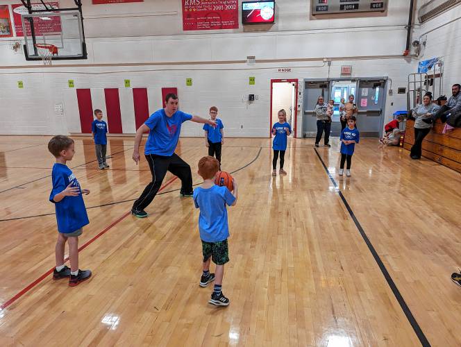 Coach Jeremy Dionne shows pre-K and kindergarten players some passing drills.